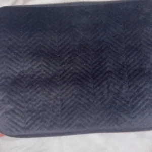 Svart quiltad datorfodral  - Snyggt svart datorfodral med quiltat mönster och dragkedja. Perfekt för att hålla dina saker säkra och stiliga. Enkel och elegant design. 