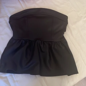 Svart tubtopp från Divided - Snygg svart tubtopp från Divided med dragkedja bak. Köpte här på plick men säljer tyvärr för att den inte satt så fint på mig