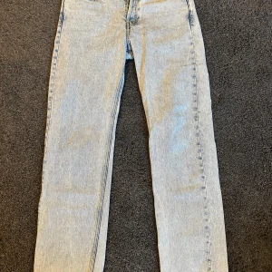 Ljusblå jeans från Arket - Säljer ett par ljusblå jeans från Arket i 100% ekologisk bomull. De har en loose passform och klassisk femficksdesign. Perfekta för en avslappnad stil.