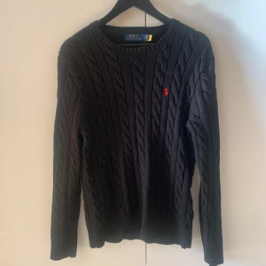 Svart kabelstickad tröja från Polo Ralph Lauren - Säljer en skön kabel stickad tröja från polo Ralph Lauren. Tröjan är i mycket bra skick och är inte använd speciellt mycket då den är för stor för mig. Tröjan är stor i storleken och sitter som M men är egentligen storlek S. (Nypris 2199) mitt pris 999 kr