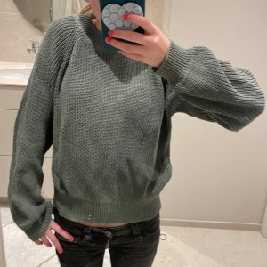 Grön stickad tröja - Säljer en mysig grön stickad tröja med långa ärmar och ribbade sömmar. Säljer pga att den inte kommer till användning. Använt ett fåtal gånger men har inga frakturer