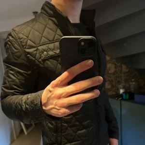 Svart jacka från Zara - Snygg svart jacka från Zara med dragkedja och knappar. Jackan har en stilren design med långa ärmar och en krage. Jackan är tunn och därför perfekt nu till våren! 