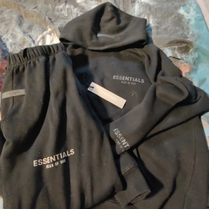 Svart Tracksuit Från Essentials - Jag säljer nu min Tracksuit från essential har knappt använt hoodien eller byxorna pga dom är för små. Inga hål eller fläckar som nya. Storlek M på båda hör av er vid funderingar.