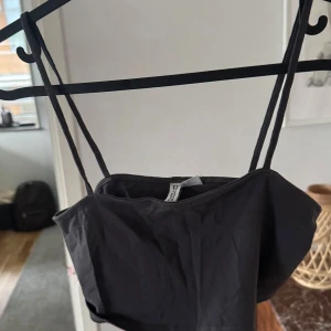 Marinblå ish topp - Snygg svart tubtopp med smala axelband. Perfekt för en stilren look. Passar bra till både jeans och kjol.