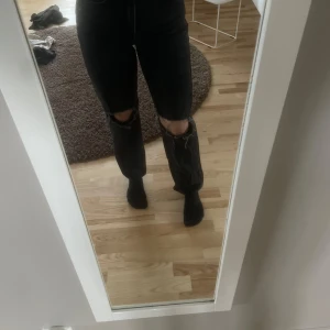 Svarta jeans med slitningar från Perfect Jeans - Snygga svarta jeans från Perfect Jeans med slitningar på knäna. De har en klassisk femficksdesign och en bekväm passform. Perfekta för en avslappnad stil.