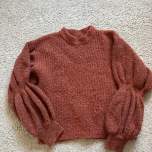 Stickad tröja  - Orange stickad tröja med puff ärmar, den är i väldigt bra skick