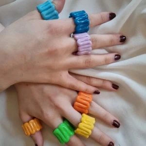 Färgglada (pride) ringar i plast - Säljer ett set med sju färgglada ringar i plast. Ringarna har en vågig design och kommer i färgerna orange, gul, grön, ljusblå, blå och lila. Perfekt för att lägga till en pop av färg till din outfit! De är perfekta inför pride men tyvärr för stora för mig 💔 5 kr styck, 35 kr för alla