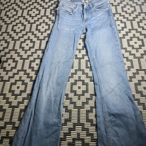 Lågmidjade jeans - Ett par ljusblåa Lågmidjade jeans i bra skick, på sida 5 ser man ett litet hål, går att reparera enkelt men säljer på grund av detta