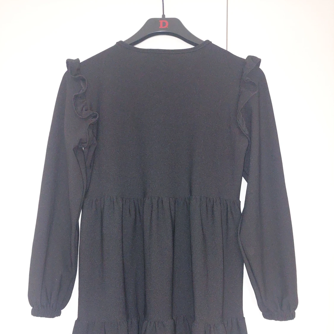 Svart långärmad klänning med volang