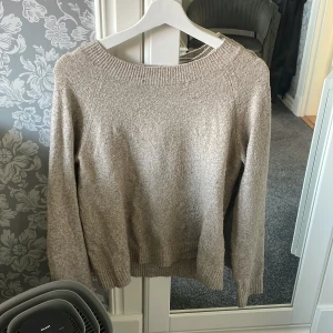 Beige stickad tröja från Vero Moda - Mysig beige stickad tröja från Vero Moda med rund halsringning och långa ärmar. Perfekt för lager-på-lager och passar till många olika outfits.