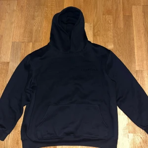 Essentials FOG hoodie - skön och mjuk hoodie från märket FOG. Storlek: L