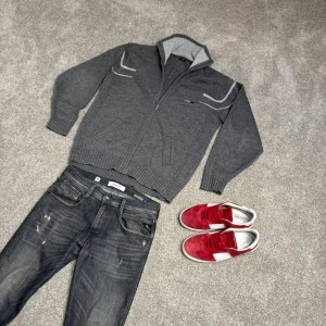 Grå stickad kofta med dragkedja från Impidimpi - Säljer en grå stickad kofta från Impidimpi med dragkedja och hög krage. Storlek L men sitter som Xl. Stor i armarna. Köp för endast 199. 