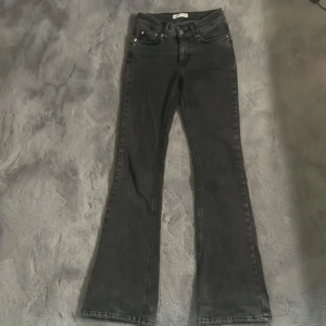 Svarta bootcut jeans från Gina - Snygga svarta jeans från Gina tricot med bootcut-passform. Klassisk femficksdesign och normalhög midja. Perfekta för dig som vill ha en tidlös look med lite utsvängda ben.😊midjemåttet är 32 rakt över, innerbenslängden är 78!💕de är nästan som nya använd dessa jeans en gång!