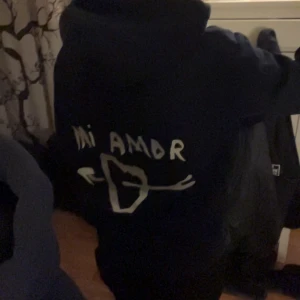Mi amor hoodie - Säljer en svart hoodie från Mira Paris i ekologisk bomull. På ryggen står det 'Mi Amor' med ett hjärta och pilar. Säljer då den inte används längre ❤️.
