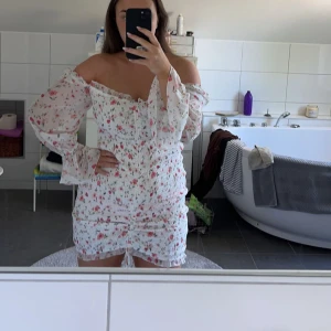 Blommig klänning - Säljer en supersöt klänning som har drapering i midjan och genomskinligt tyg på armarna🩷 Går att ha både som off-shoulder och på axeln. Perfekt till sommaren och midsommar!