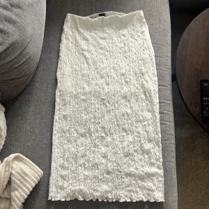 Vit långkjol i spets Ginatricot  - Säljer en vit långkjol med snygg spets. Har en innerkjol som sträcker sig ungefär hälften av kjolen. Sitter jättefint. Storlek L 