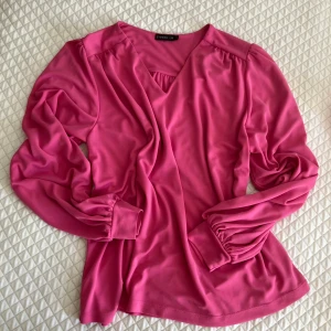 Cerise blus - Säljer en fin blus med härligt fall.