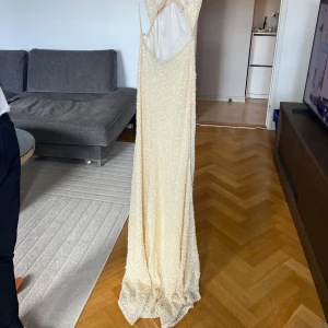 Ljusgul långklänning med paljetter och smala axelband - Säljer en ljusgul långklänning från dressrom linne. Den har smala, korsade axelband och v-ringad urringning. Klänningen är täckt av paljetter och har öppen rygg. Perfekt för balen, hör av er vid frågor!🌸🤍