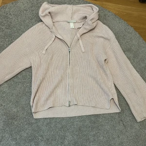 Ljusrosa stickad hoodie med dragkedja från Monki - Säljer en ljusrosa stickad hoodie från Monki i storlek S. Tröjan har dragkedja framtill, huva med dragsko och långa ärmar. Perfekt för lager-på-lager och chill dagar. Helt slutsåld online vad jag hittade. Köpt för runt 300. Använd ett fåtal gånger, så den är i väldigt bra skick!💗