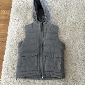 Grå väst med luva från Stenströms - Grå väst från Stenströms i storlek medium. Köpte den för 4000 typ, haft den några gånger men har andra västar som jag använder istället så har hängt mest hemma. Riktigt bra skick. 