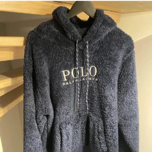 Ralph Lauren Fleece Hoodie  - En otrolig snygg och skön fleece hoodie från Ralph Lauren i färgen navy blue. Hoodien är i nyskick och är aldrig använd, har inga som helst defekter eller skador alls. Priset är inte hugget i sten och går att diskuteras vid en snabb och smidig affär. Vid några som helst frågor eller funderingar så är det bara att höra av dig. MVH Stockholm Wardrobe 😄