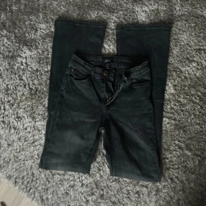 Svarta bootcut jeans från ONLY XS - Snygga svarta jeans från ONLY i bootcut-modell. Jeansen har klassisk femficksdesign, dragkedja och knapp framtill samt bälteshällor. Materialet är jeans med en lätt tvättad look. Perfekta för dig som gillar en tidlös och trendig stil.