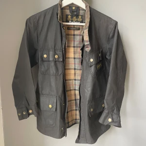 Oljejacka Barbour  - Klassisk Barbour jacka väl använd men har mycket kvar att ge. Storlek small. 