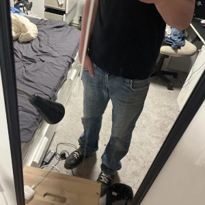 Blå Levis 506 jeans straight fit - Klassiska blå Levis 501 jeans med rak passform och normal midja. Jeansen har fem fickor, knappgylf och är tillverkade i slitstarkt bomullsjeans. Perfekta för en avslappnad och tidlös stil.