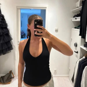 Svart ribbad halternecktop från NA-KD - Svart ribbad halternecktop från NA-KD med djup v-ringning! 🖤 Säljer pga att den inte kommer till användning! Använd en gång så den är i jättebra skick!! Storlek s men passar även M