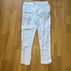 Vita linnebyxor från Zara med snörning - Snygga vita linnebyxor från Zara i storlek 38. Byxorna har dragsko i midjan, raka ben och fickor både fram och bak. Perfekta för en chill och stilren look under varmare dagar.