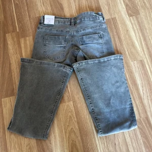 Grå bootcut jeans från Gina Tricot XS - Snygga eftertraktade lågmidjade bootcut  regular jeans från Gina 14+. Nya med prislappen kvar, dem är bara testade! Därav inga deffekter 💕helt slutsålda på hemsidan. Dem är i strl XS skriv för fler funderingar!💓köpta för 360kr. pris går att diskutera!