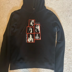 Svart Saint Laurent hoodie XS men passar S - Svart hoodie från Saint Laurent med tryck av svartvita foton och röda ramar på bröstet. Perfekt för dig som gillar streetstyle och vill sticka ut med ett coolt print.