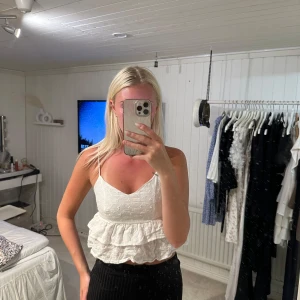 Vit linne topp med volanger  - Superfin vit linnetopp med tunna axelband och volangkant. Toppen har broderade blommor🥰