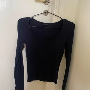 Svart långärmad topp med rund hals - En svart långärmad topp med rundad halsringning. slits vid armsluten! 
