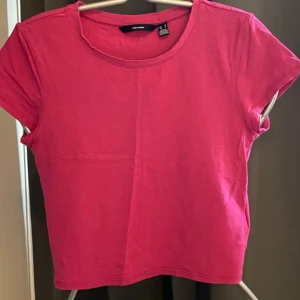 Topp från Vero Moda!  - Rosa kortärmad topp från Vero Moda!  Är i nyskick! Modellen är kortärmad med rund halsringning och har en rak, något croppad passform. Perfekt att matcha med jeans eller kjol för en chill look.