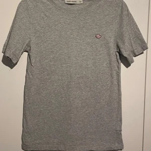  t-shirt Carin Wester!  - Gråmelerad t-shirt från Carin Wester i 100% bomull. Klassisk passform med korta ärmar och rund halsringning. läppar som ger en cool  Fint skick! Inga skador eller anmärkningar! 