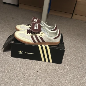 Adidas Wales Bonner Samba sneakers - Unika Adidas Wales Bonner Samba sneakers i beige och vinröd mocka och skinn. Klassiska tre ränder på sidan, grovstickade detaljer och brun gummisula. Tungan har kontrasterande sömmar och Wales Bonner branding. Perfekt för dig som vill sticka ut med stil. Tar gärna i mot byten😀