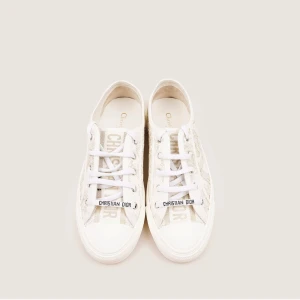 Vita sneakers från Christian Dior - Snygga vita sneakers från Christian Dior med loggan på. Skorna har en vit sula med svart stjärndetalj undertill och är tillverkade i textil med diskret mönster. Perfekta för dig som vill ha en exklusiv och trendig look. Skorna är i storlek 39,5 och boxen finns kvar:) Skorna är bara använda 1-2 ggr (MYCKET bra skick!) Priset går att diskutera🤍