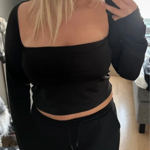 Svart croppad långärmad topp - Säljer en svart, croppad topp med lång ärm och fyrkantig urringning.
