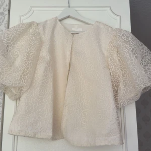 Beige overshirt med puffärm L - Superfin beige blus med broderade blommor och stora puffärmar. 