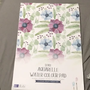 Aquarelle Water Colour Pad - A3 akvarellblock med 20 ark, 200 g/m², perfekt för dig som vill skapa snygga akvarellmålningar. Fint grängat papper som passar både nybörjare och kreativa unga vuxna. Inspirerande blommigt omslag. Den har väldigt tjockt papper som du kan göra vad som helst med