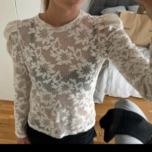 Vit spetsblus med puffärm från Lindex - Superfin vit spetsblus från Lindex med lång ärm och puffiga axlar. Blusen har ett blommigt spetsmönster och rund halsringning. Vet inte exakt storlek men skulle säga att den passar xs-s🩷
