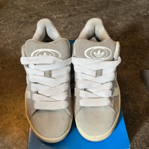 Adidas Campus i grå - Säljer mina Adidas Campus skor i ljusgrått, som är köpta från Nelly. Dessa är i storlek 36,5 och de har blivit använda ett par gånger men de ser knappt använda ut.