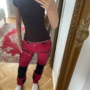 Röda arbetsbyxor - Jag säljer ett par röda och svarta arbetaebyxor nya inga defekter de är av väldigt bra och tålig kvalite. Köpte till spex då de inte blivit använda igen