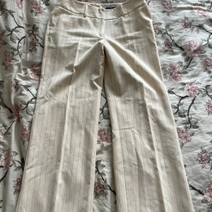 Ljusbeiga kostymbyxor - Ljusbeiga, randiga vida kostymbyxor från ELEMENTS! Jag skulle säga att de passar s-m. De har två supersmå ”fläckar” på ena benet men de syns knappt, skriv om bilder på det önskas så skickar jag! Annars jättebra skick. 