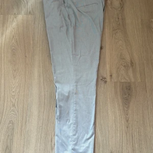 Kostymbyxor från H&M - Snygga kostymbyxor från H&M i storlek 44. Byxorna har ett diskret rutmönster, raka ben och klassisk passform. Det finns en tillhörande kavaj i storlek medium också. 