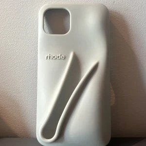 grått Rhode mobilskal med 3D-detalj - Säljer ett grått rhode skal, har nästan aldrig använt, det är till för en iphone 12👍 Det är som ett 3D skal men så stilrent! skriv privat om ni skulle vilja köpa! Köpte för 600 säljer för 500!! 