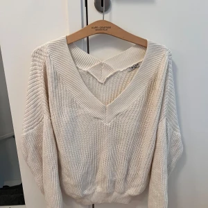 Vit stickad v-ringad tröja NA-KD - Superfin vit stickad tröja från NA-KD med bred v-ringning som gör att man även kan använda den som en offshoulder. Tröjan har långa ärmar och ribbade muddar.