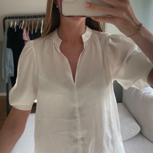 Söt blus från H&M - Krämvit blus med puffärm som sitter tajt vid mudden men har fint fall. Helt oanvänd från H&M, lappen sitter kvar. Väldigt söt lite ”finare” blus!