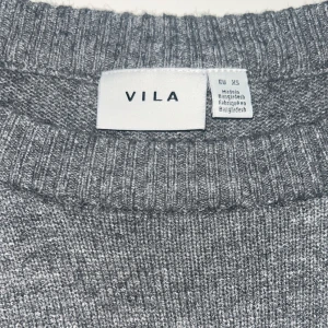Grå stickad tröja från VILA XS - Enkel och stilren grå stickad tröja från VILA i storlek XS. Tröjan har rund halsringning, ribbade muddar och lång ärm. Perfekt för lager-på-lager och passar till allt. Mjuk och skön känsla som håller dig varm under kyliga dagar.